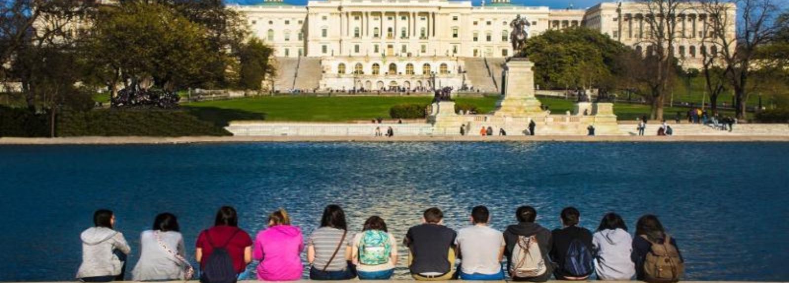 students sitting with their backs to camera looking at a building in Washington